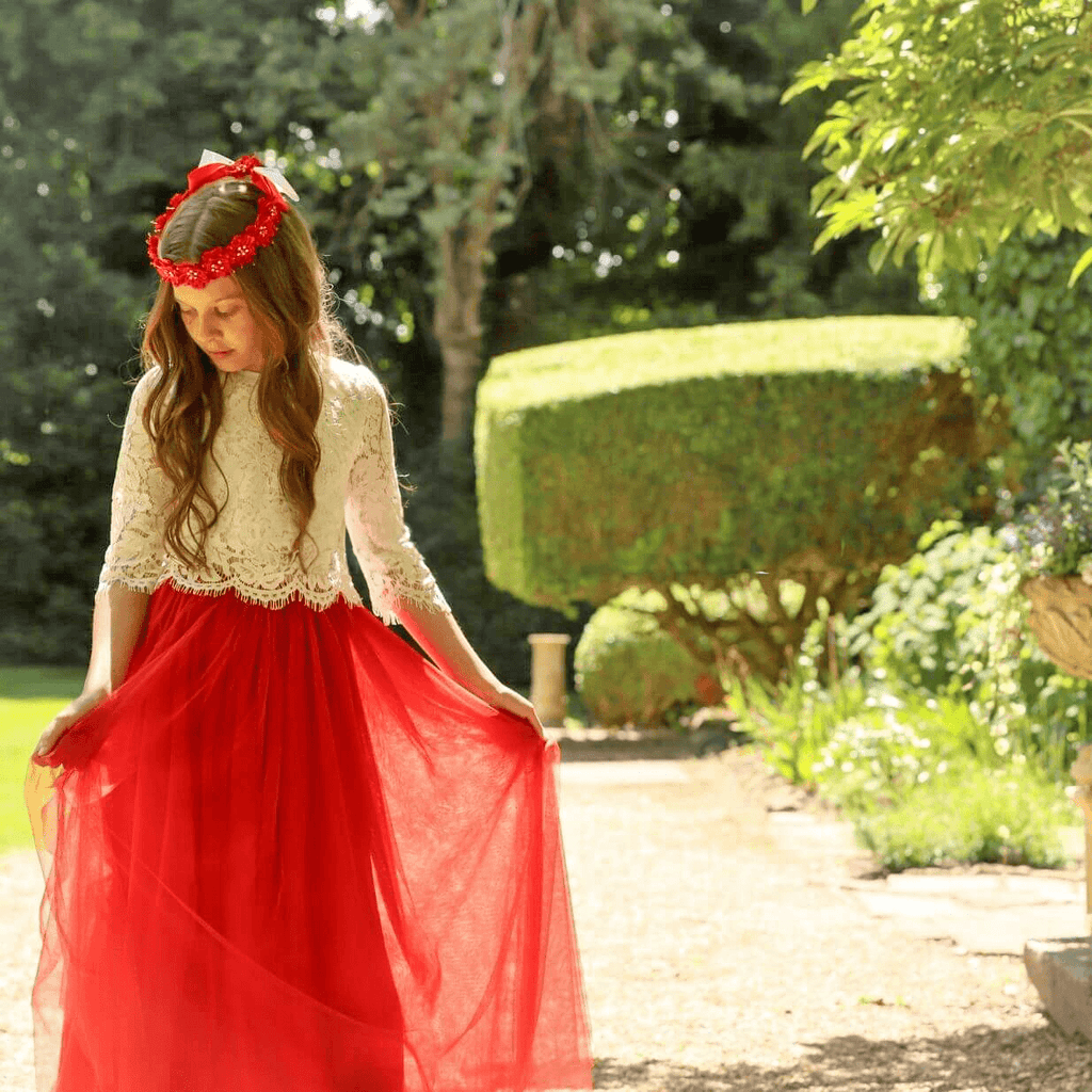 Gril in garden wearing a pretty orange and cream flower girl