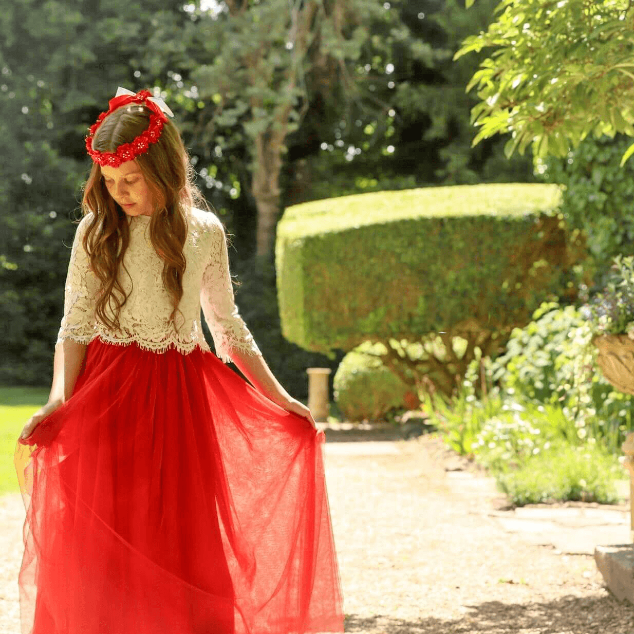 Gril in garden wearing a pretty orange and cream flower girl