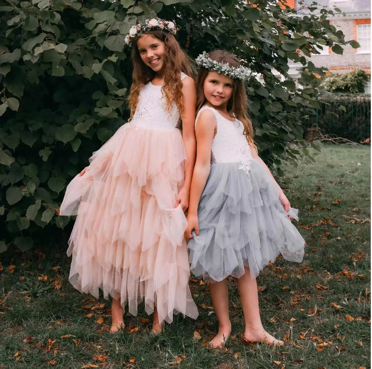 Two girls in church grounds in pretty dresses