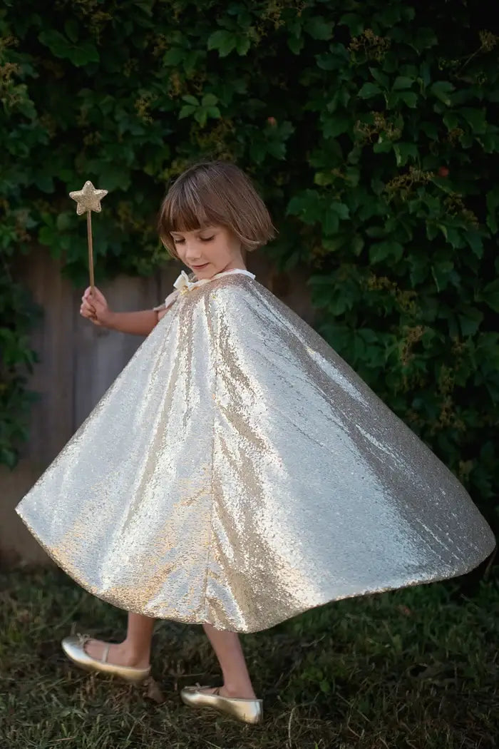 young girl holding her wand wearing her sequin cape