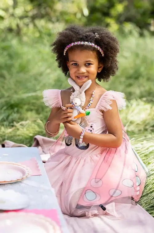 young girl playing dress up with a teddy