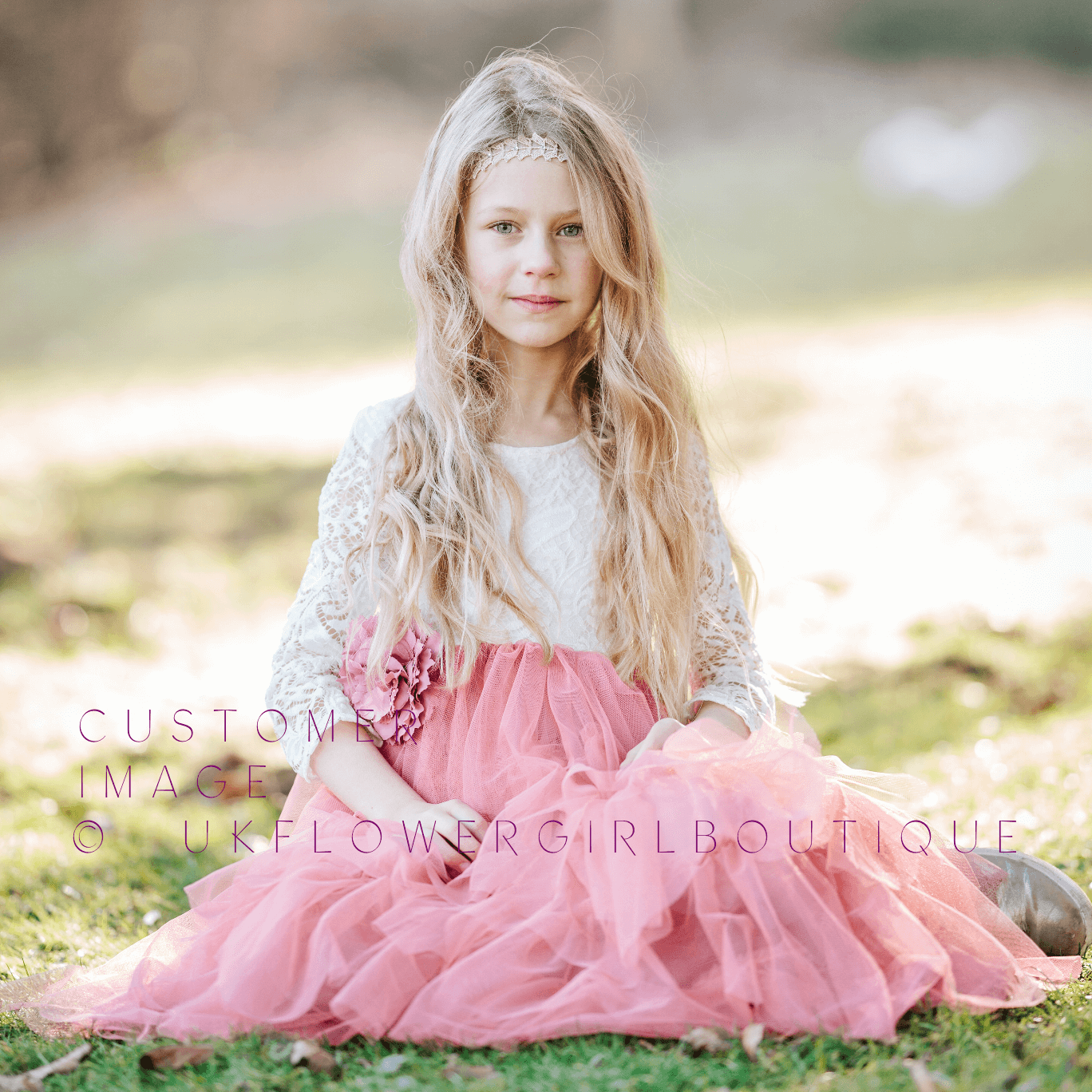 girl sitting in a park in a pink and lace dress