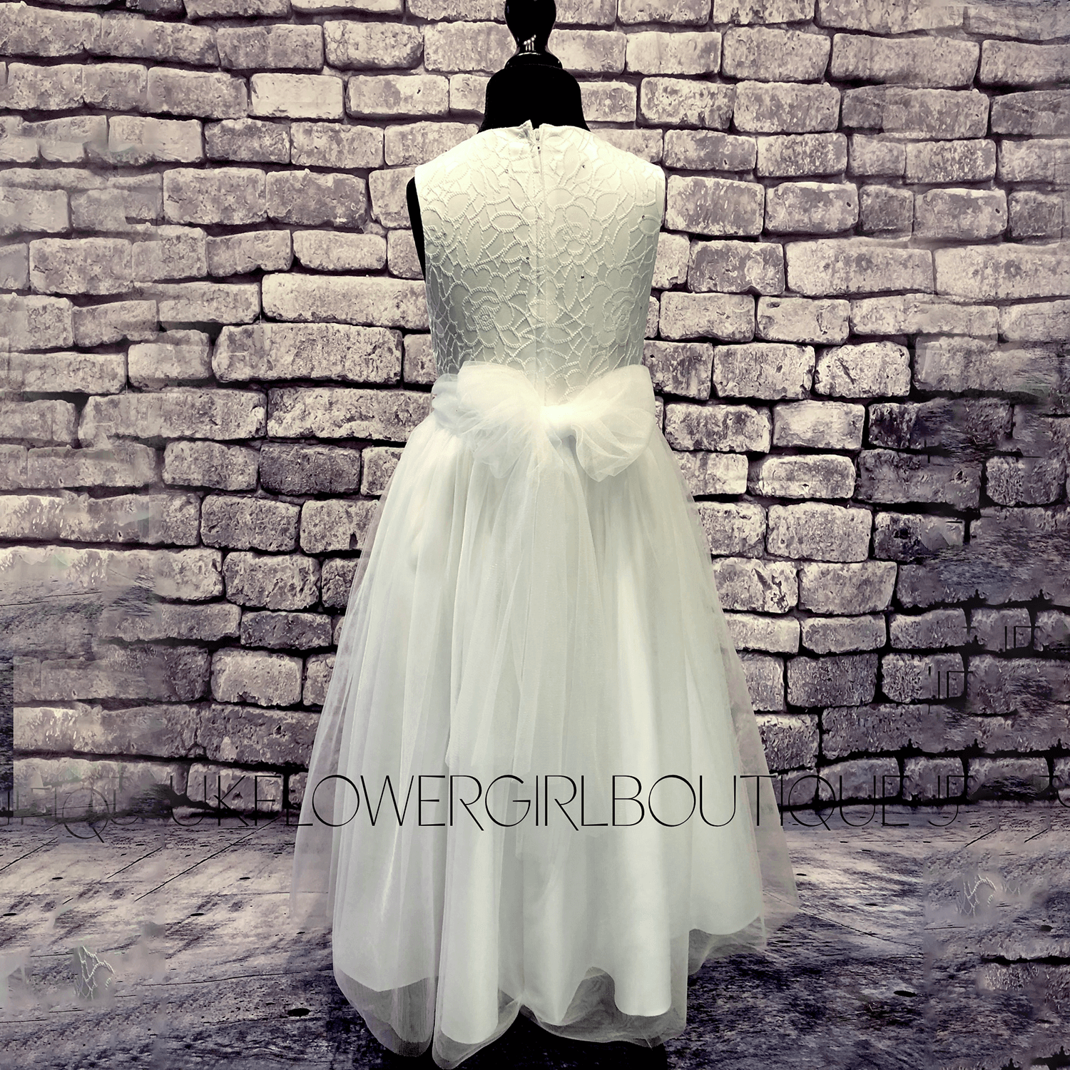 Isabella Flower Dress in with on a mannequin against a brick wall