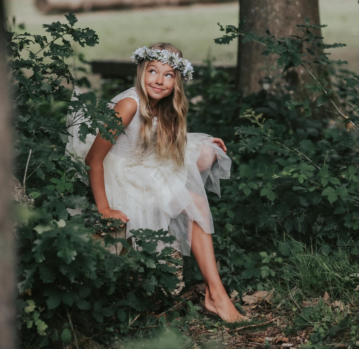 flower girl sitting by tree