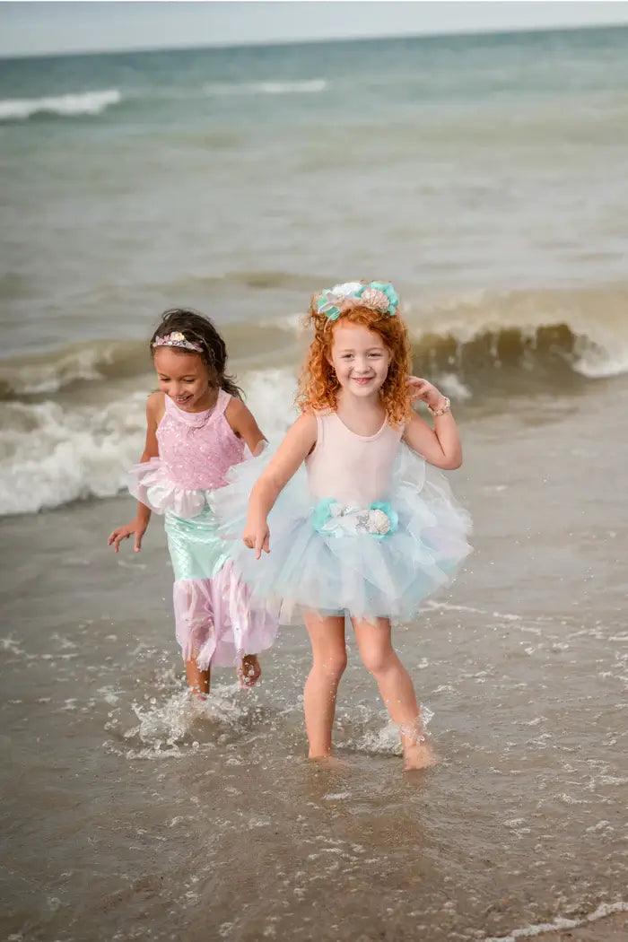 2 young girls playing in the sea in fancy dress