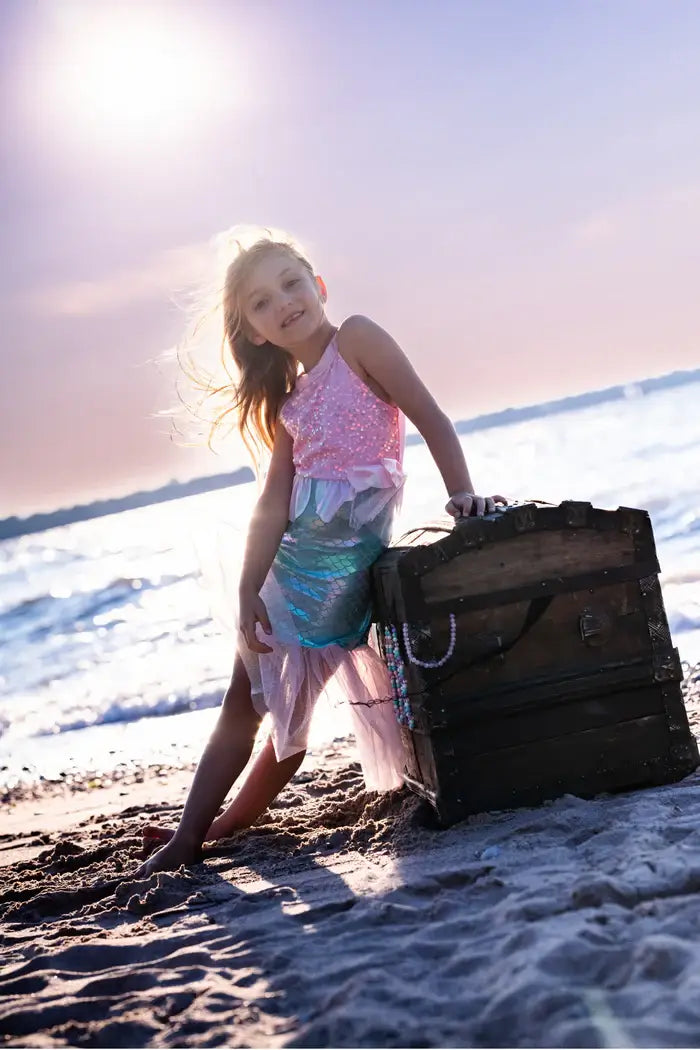 young girl dressed as a mermaid on beach
