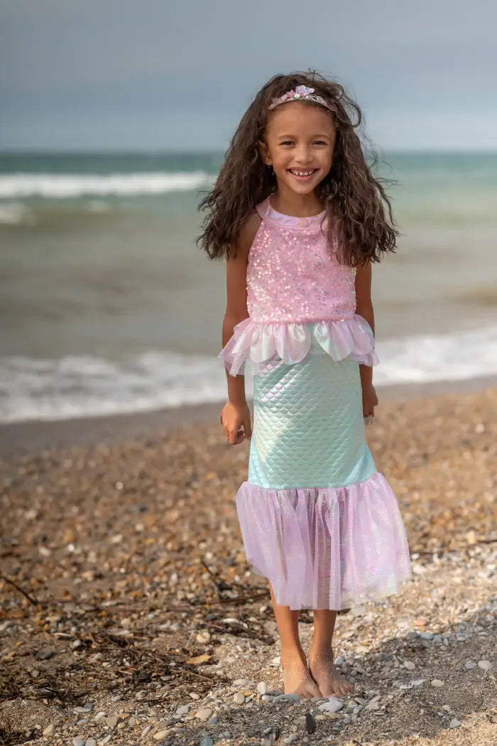 pretty girl walking on beach dressed as a mermaid