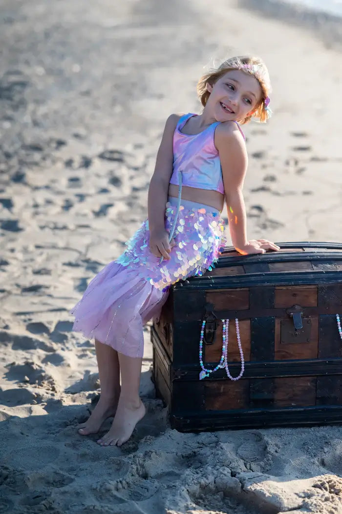 girl sitting on beach as a mermaid