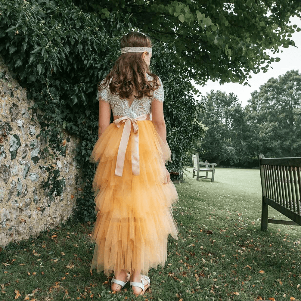 Flower girls showing off the detail on back of a yellow dress