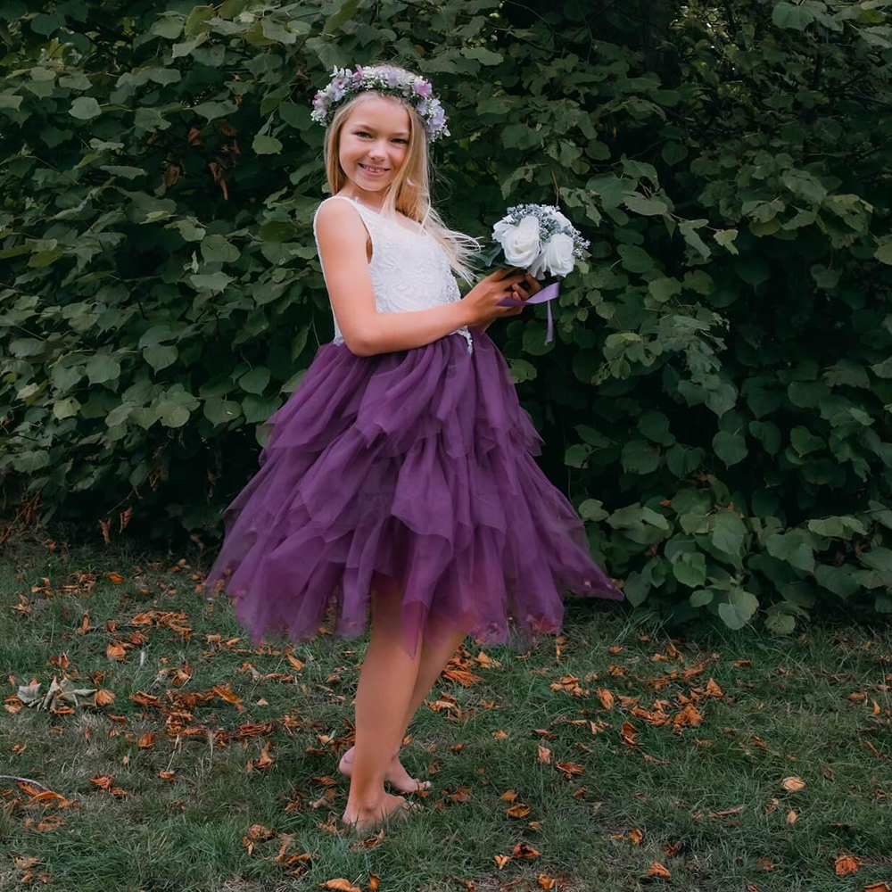 Girl in a garden wearing a Purple Flower Girl Dress