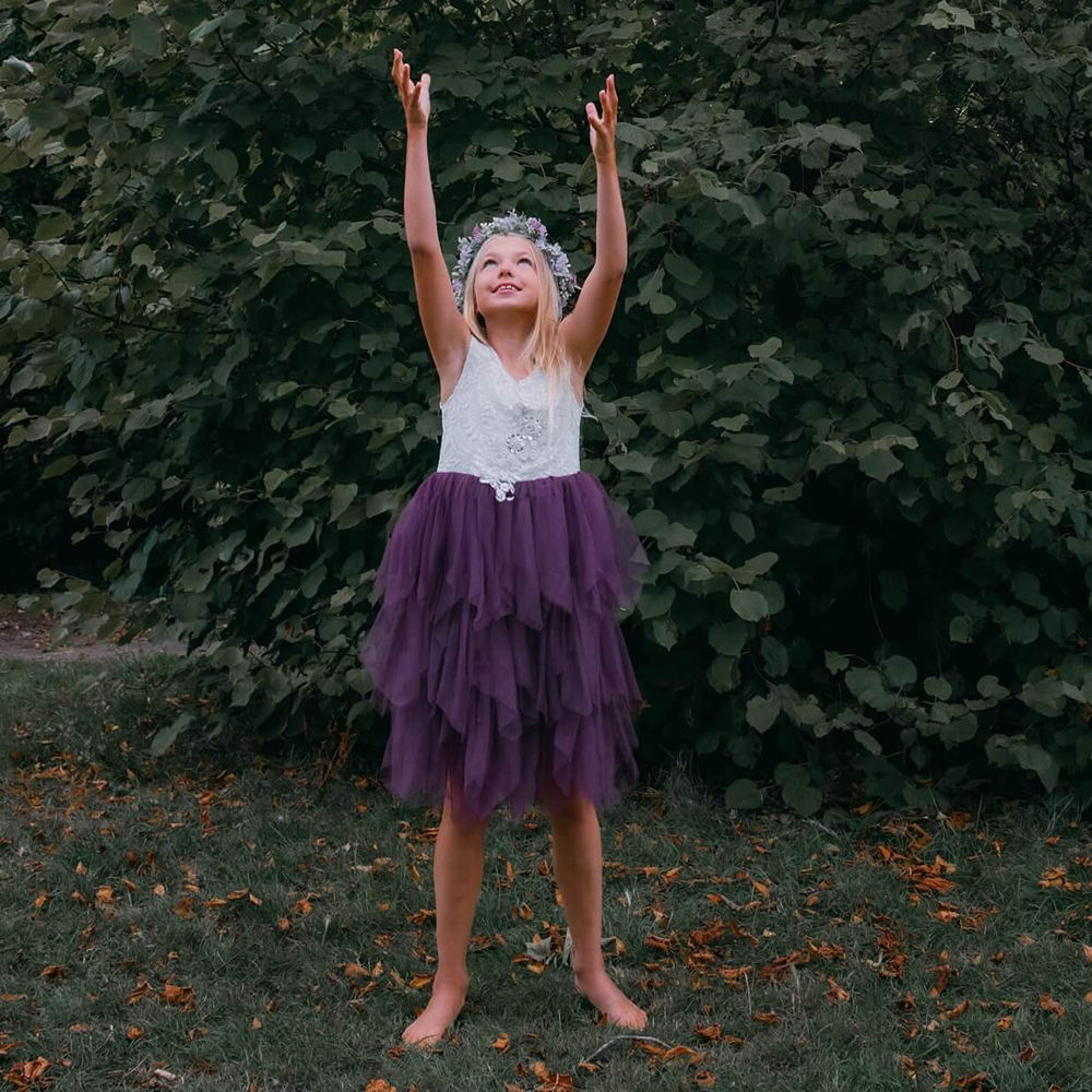 Girl in a garden wearing a Purple Flower Girl Dress