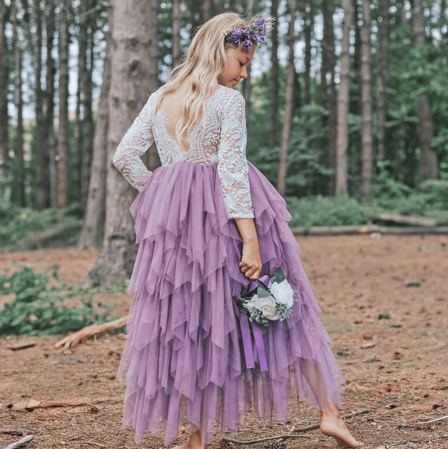 Girl stepping on log in forest wearing beautiful dress