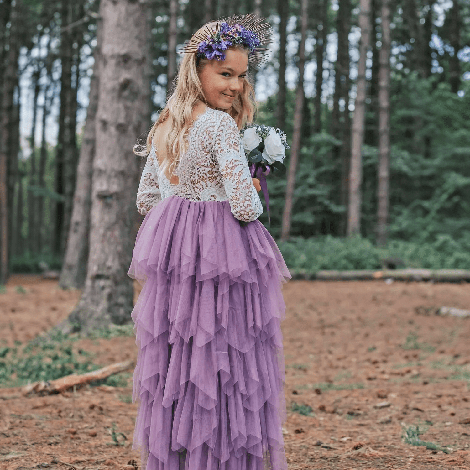 Pretty girl holding flowers wearing a flower girls dress