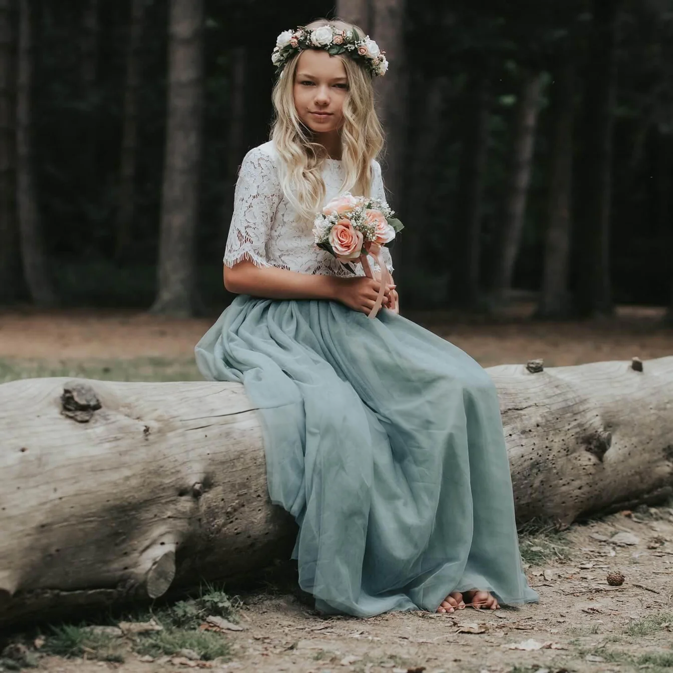 Girl sitting on log in forest