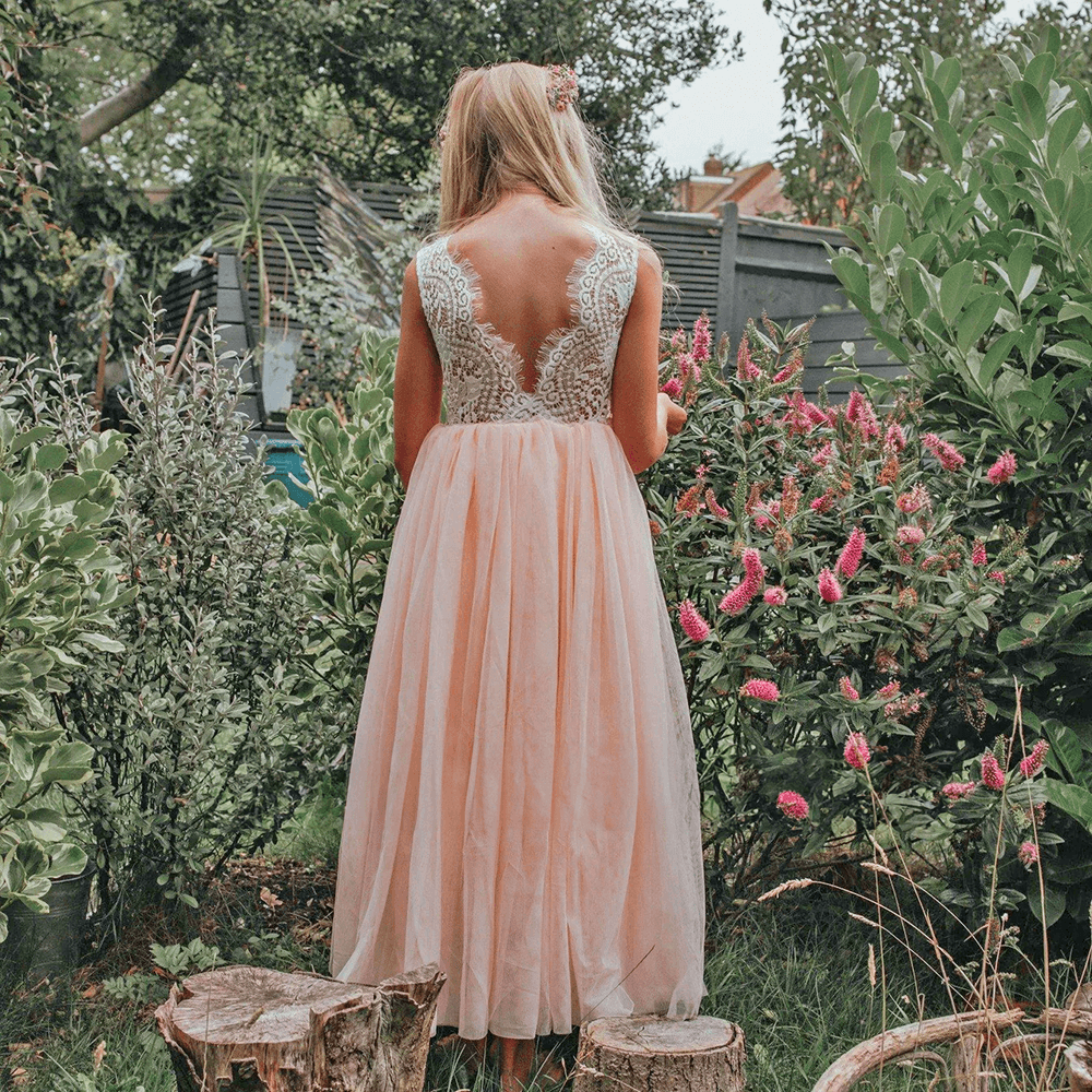 Girl in a garden wearing blush pink dress