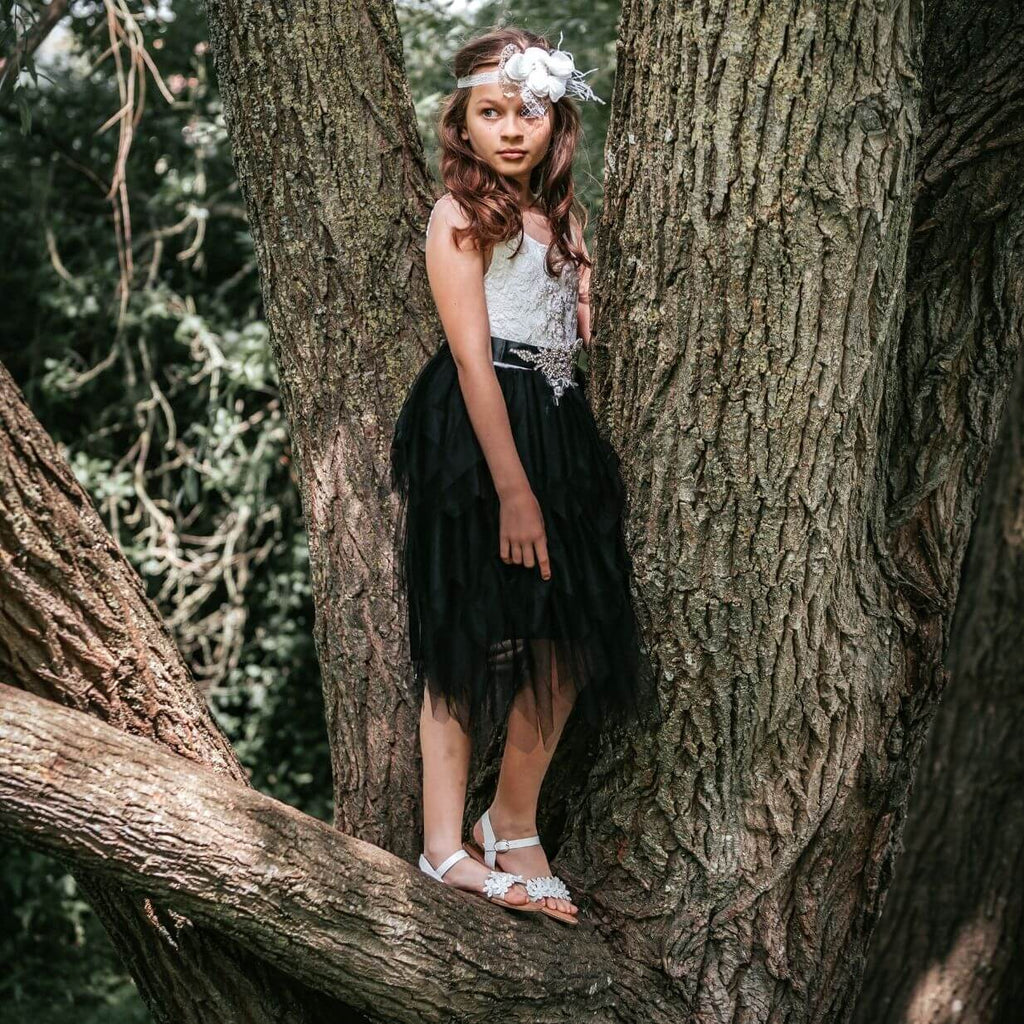 Girl playing in tree in flower girl dress