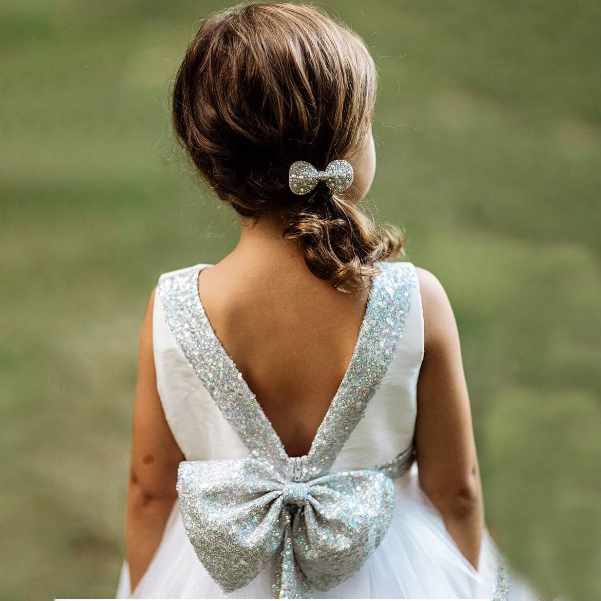 Girl wearing a silver party dress with sequin bow