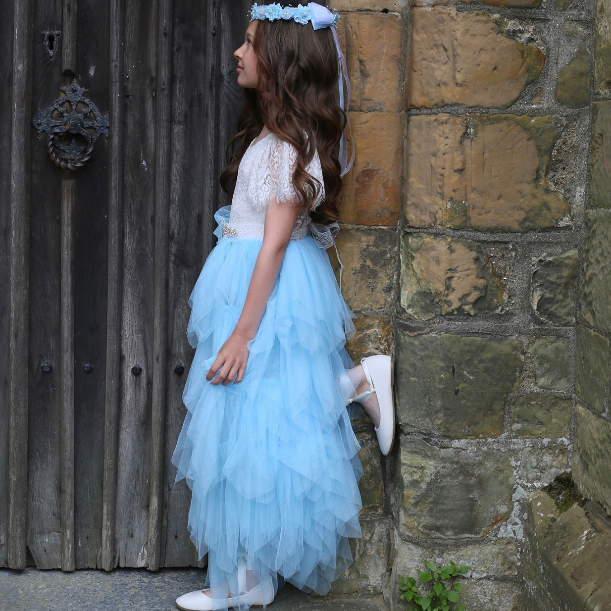 Girl standing in doorway with foot against wall