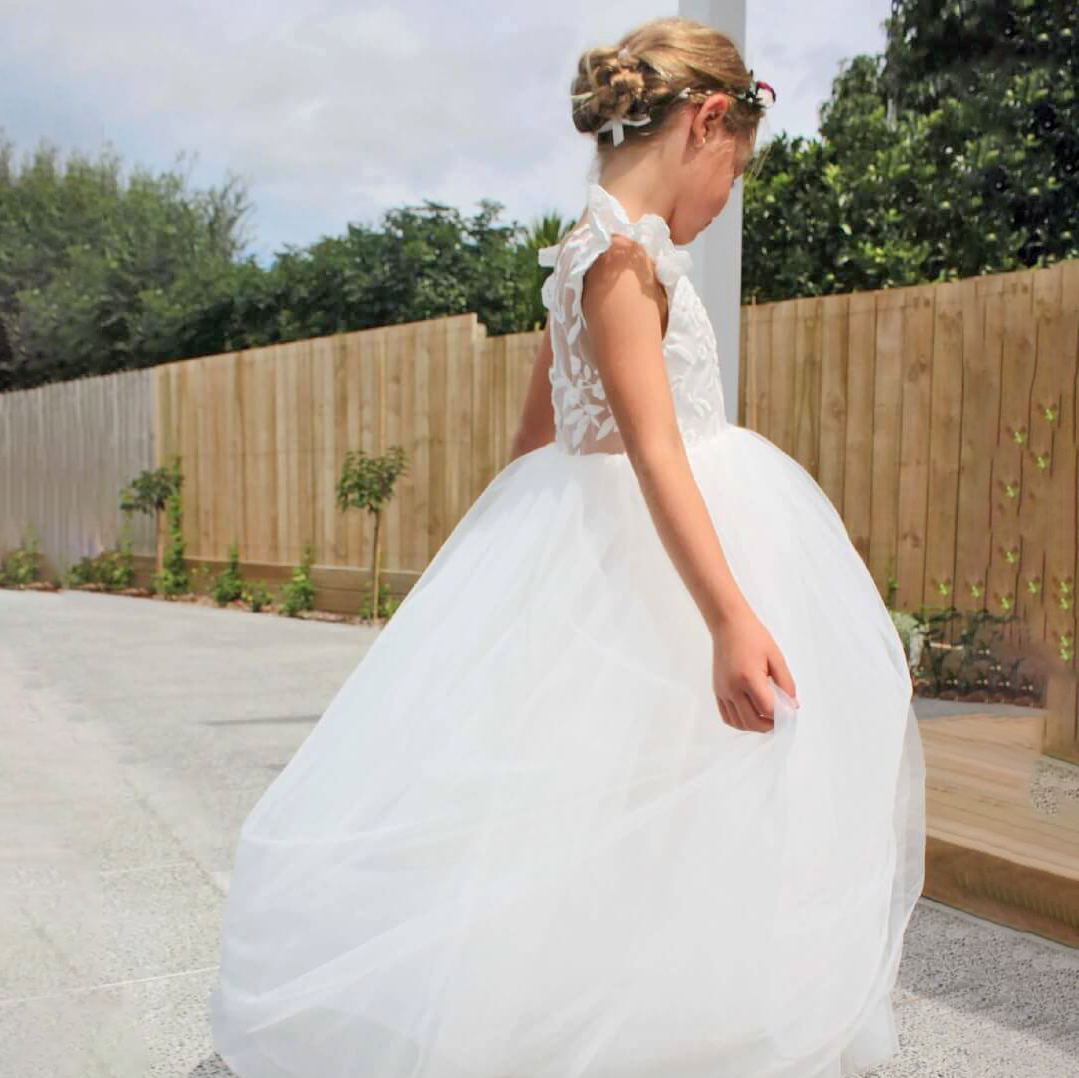 girl wearing a long white flower girls dress