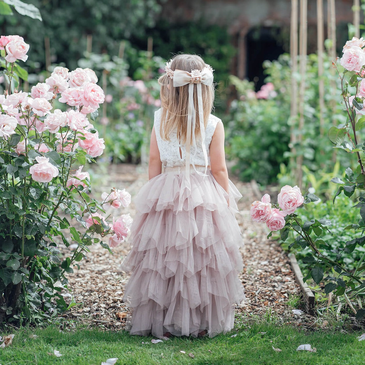 Young girl in wedding gardens wearing flower girl dress