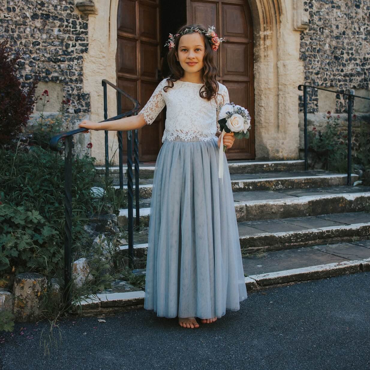 young flower girl stood by steps