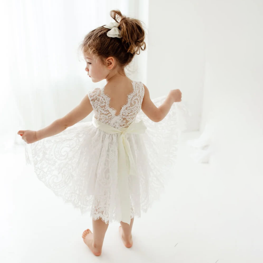 Girls playing in window in a white flower girl dress
