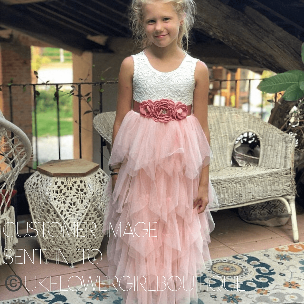 Girl wearing white and blush flower girl dress