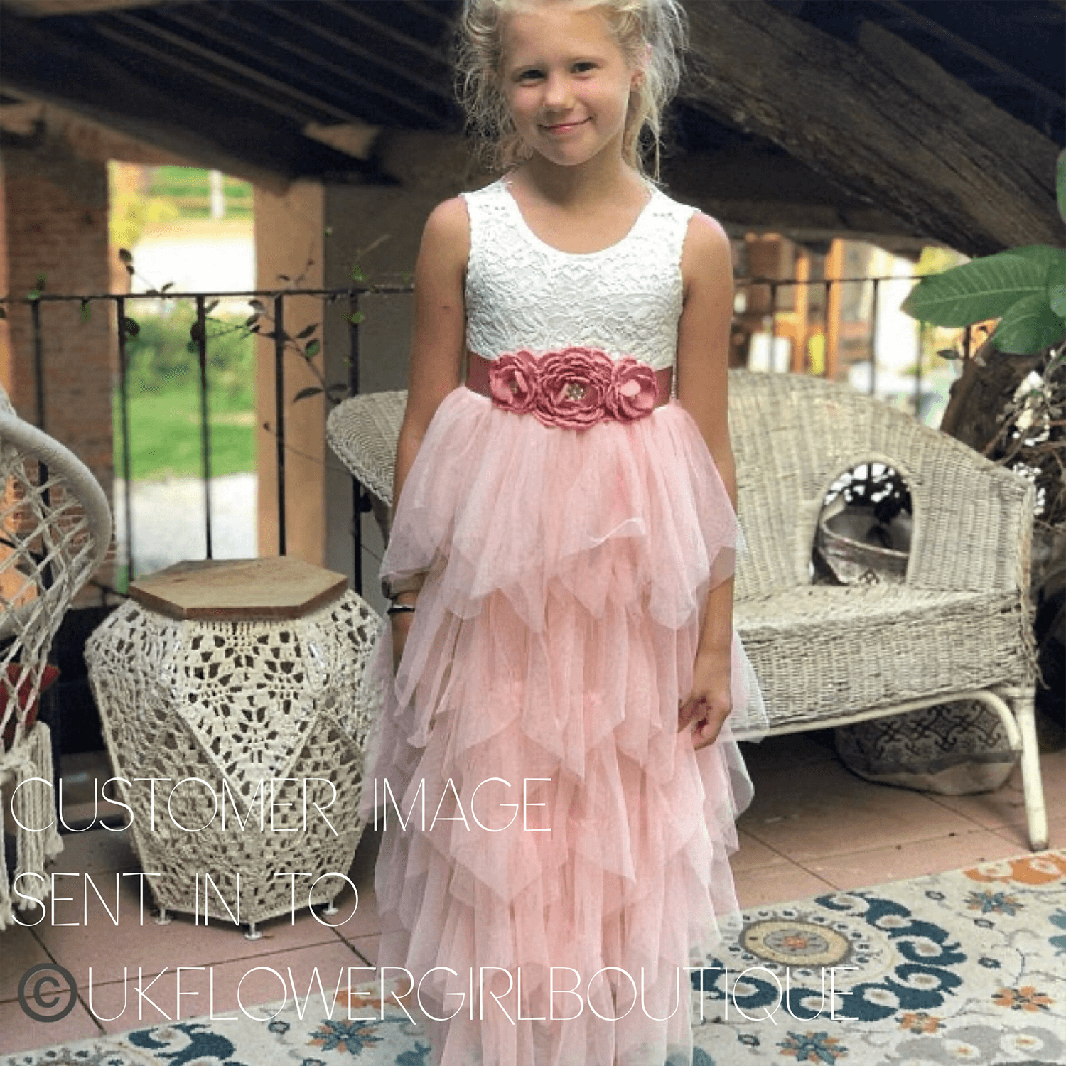 Girl wearing white and blush flower girl dress