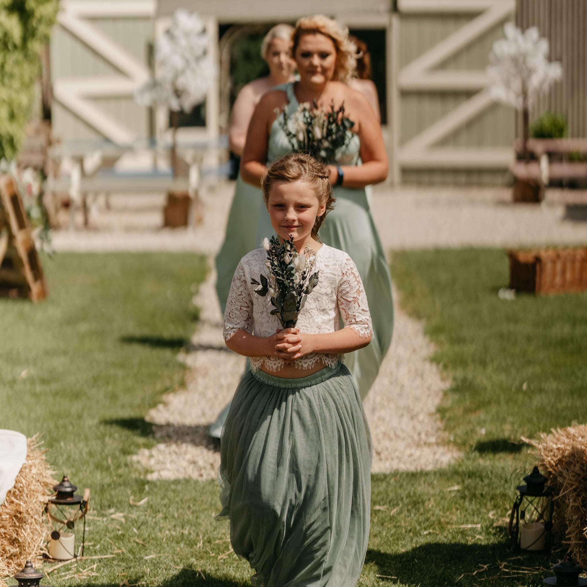 Young flower girl followed by bridesmaids
