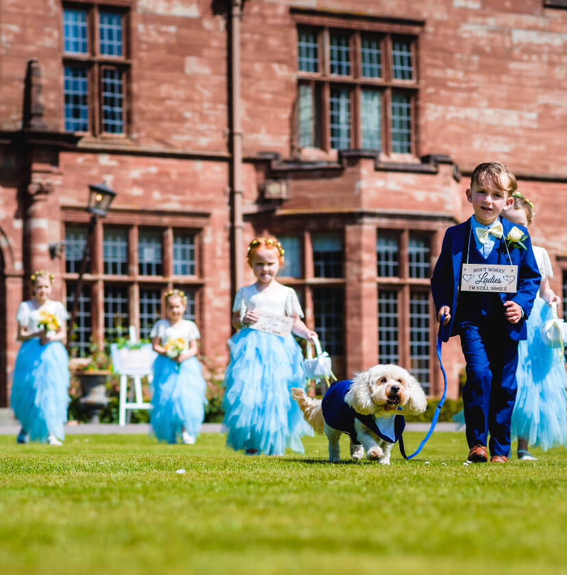 Flower girl and page boy party holding small dog