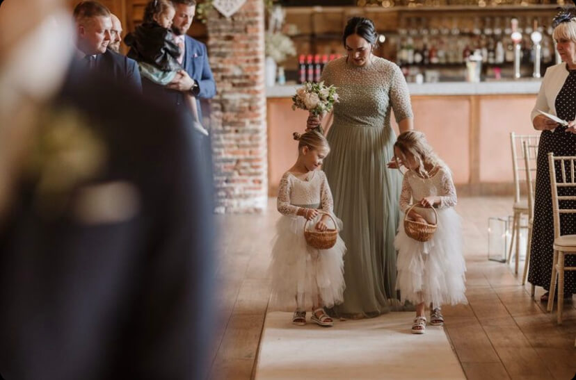 Young flower girls walking down the isle