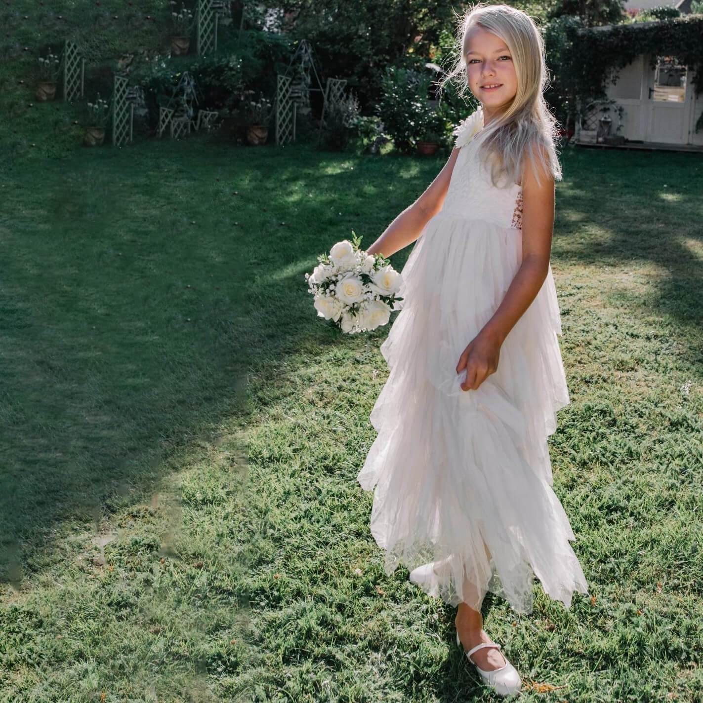 Girl in a garden wearing ivory flower girl dress
