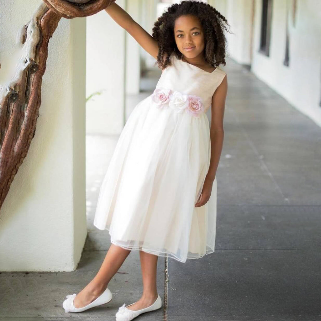 Girl leaning on a tree in a ivory flower girl dress