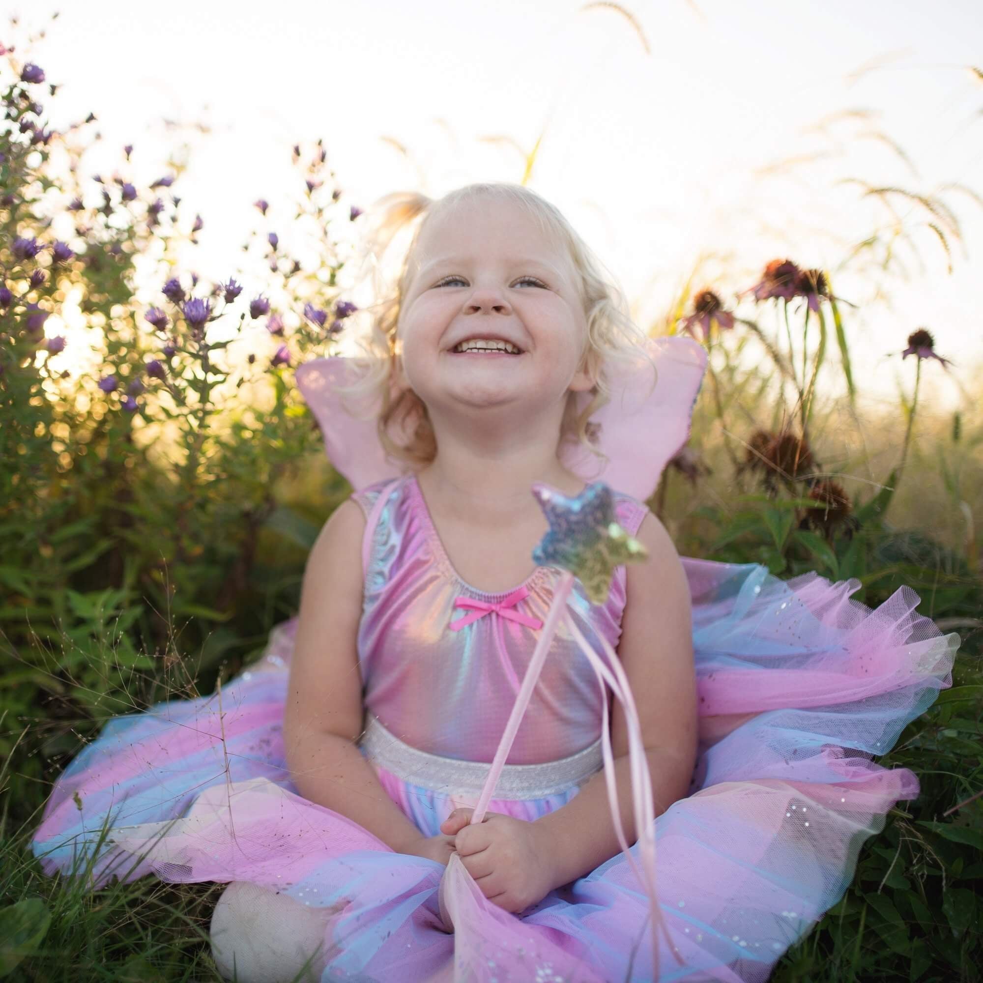 Little girl wearing pastel rainbow iridescent leotard with matching tutu skirt and wand