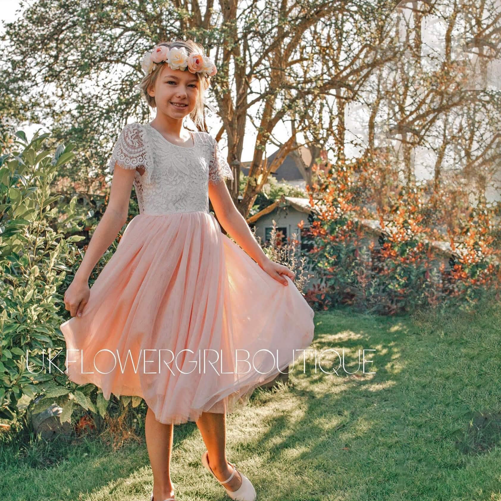 Gril in a garden in a pink and white party dress