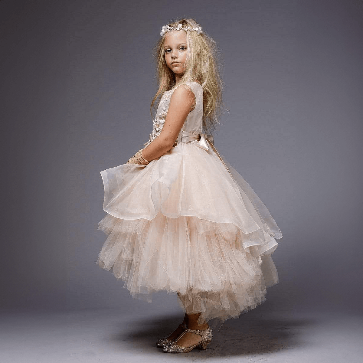 Girl wearing a blush coloured Princess Evangeline party dress