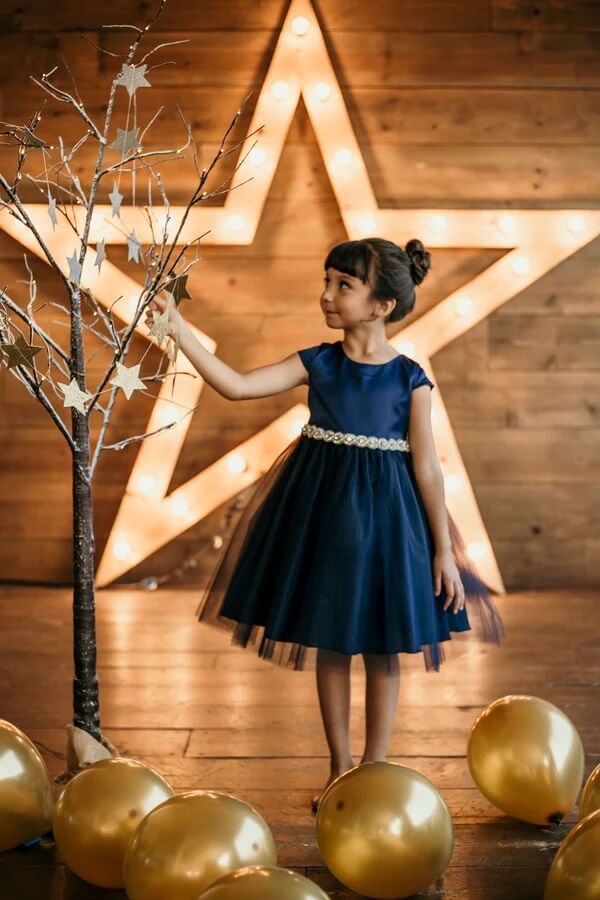 young girl standing by party balloons