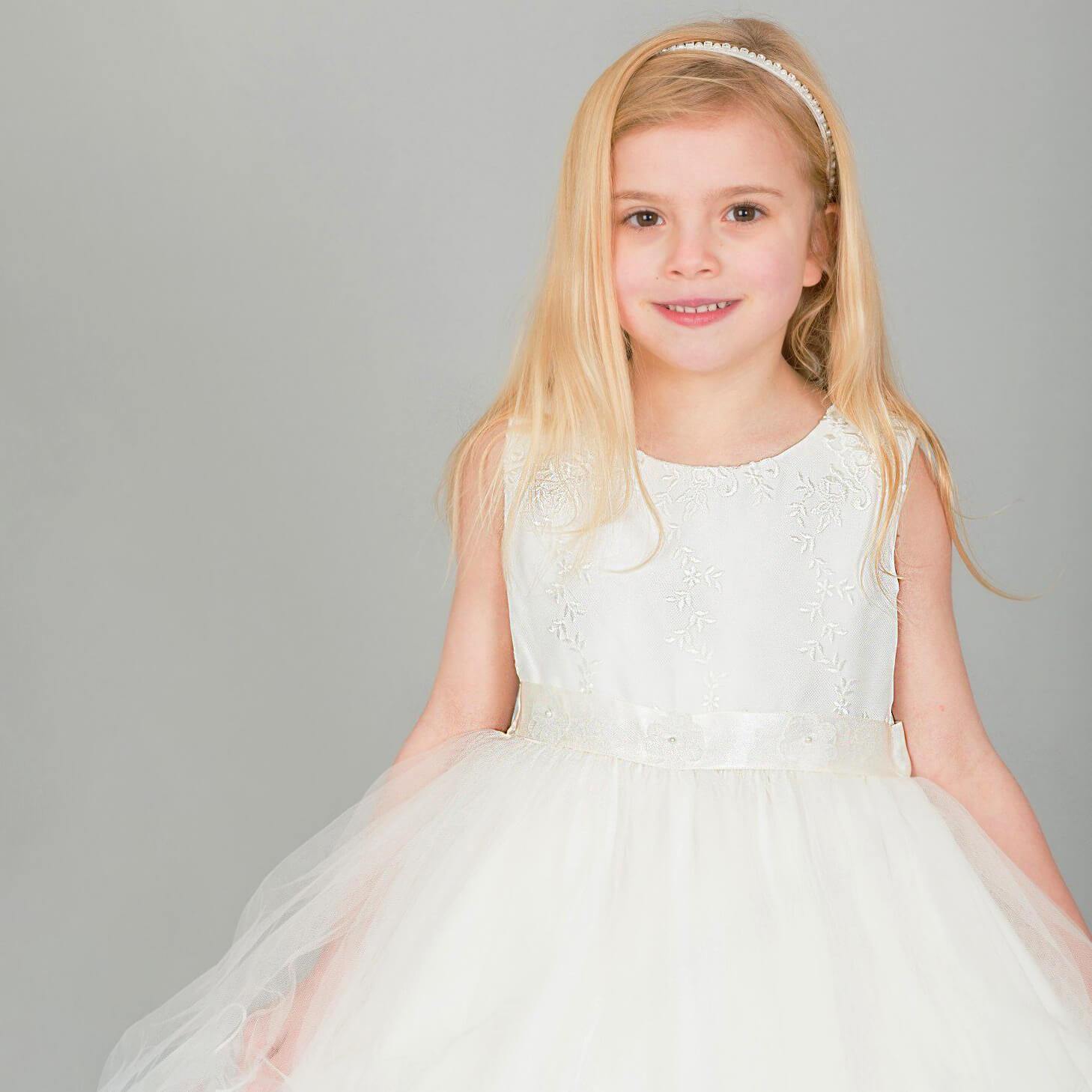 Girl wearing UK Flower Girl Boutique ivory coloured dress