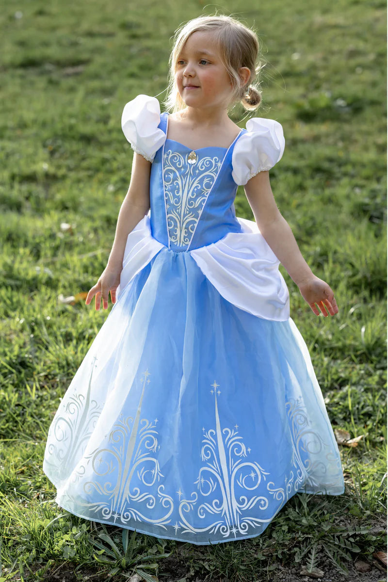 Child in a blue and white princess dress standing on grass