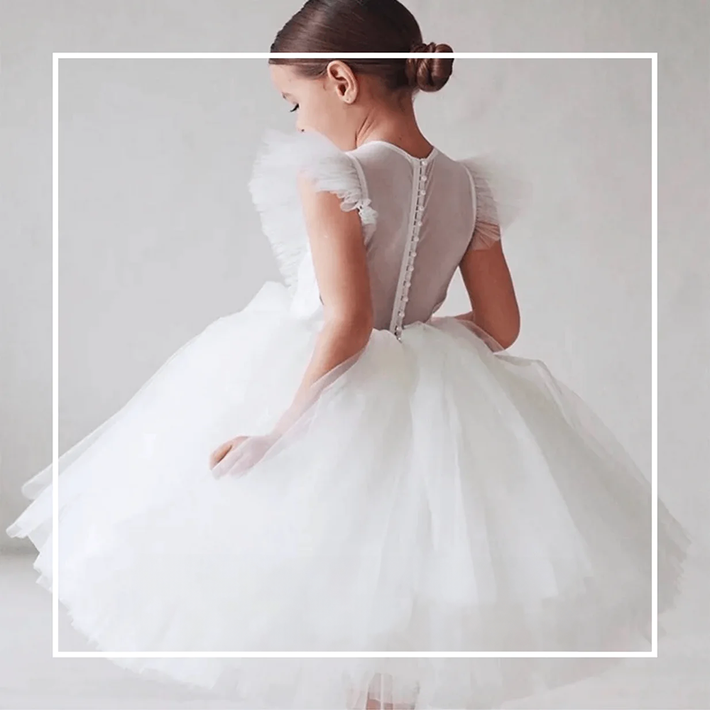 Girl wearing a white occasion dress from UK Flower Girl Boutique