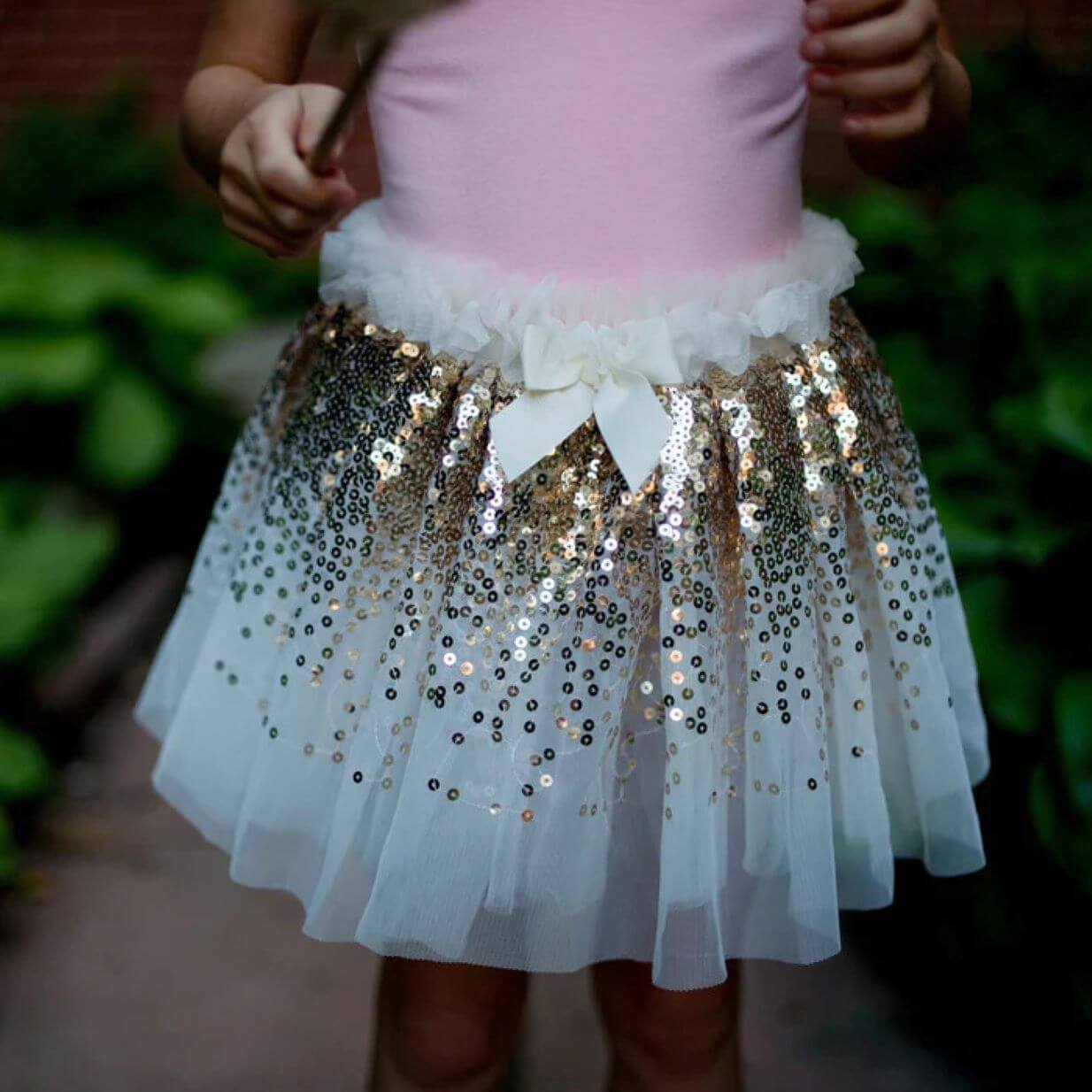 close up view of young girl wearing a white tutu skirt with gold sequins