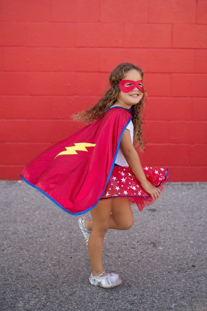 girl playing in superhero dress up 