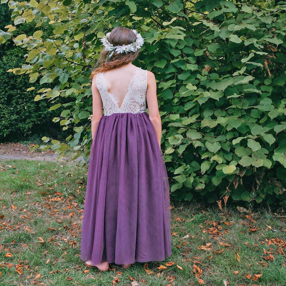 Girl wearing purple flower girl dress in a park