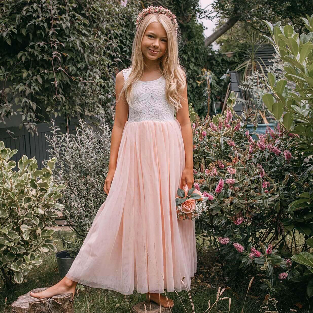Girl in a garden wearing blush pink dress