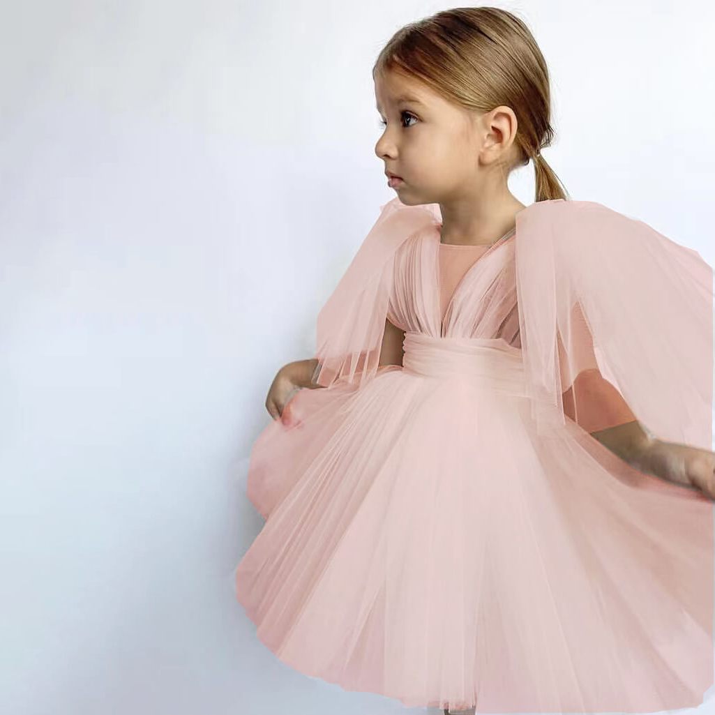 Girl wearing a baby angel dress in blush