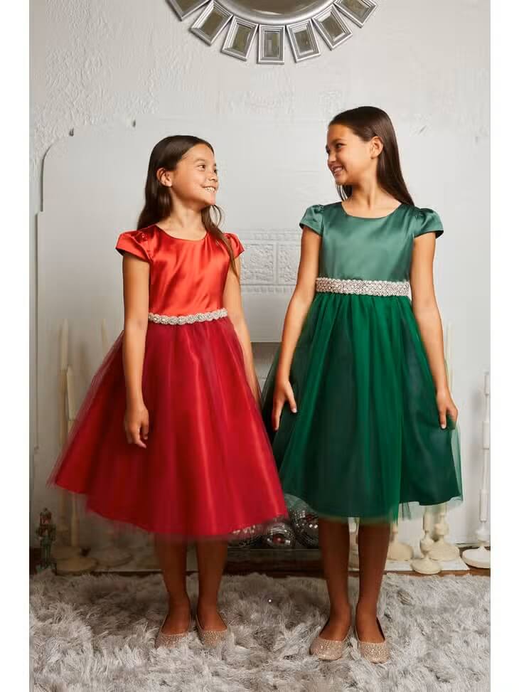 Two girls smiling holding dresses 
