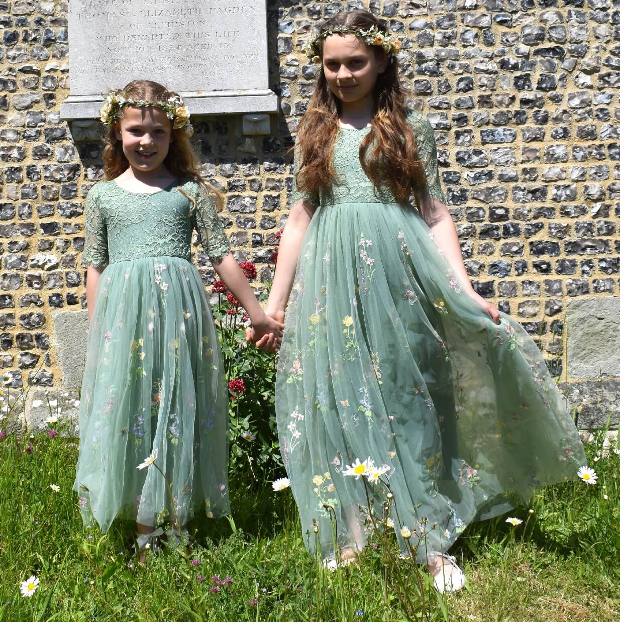 Two pretty flower girls in church grounds