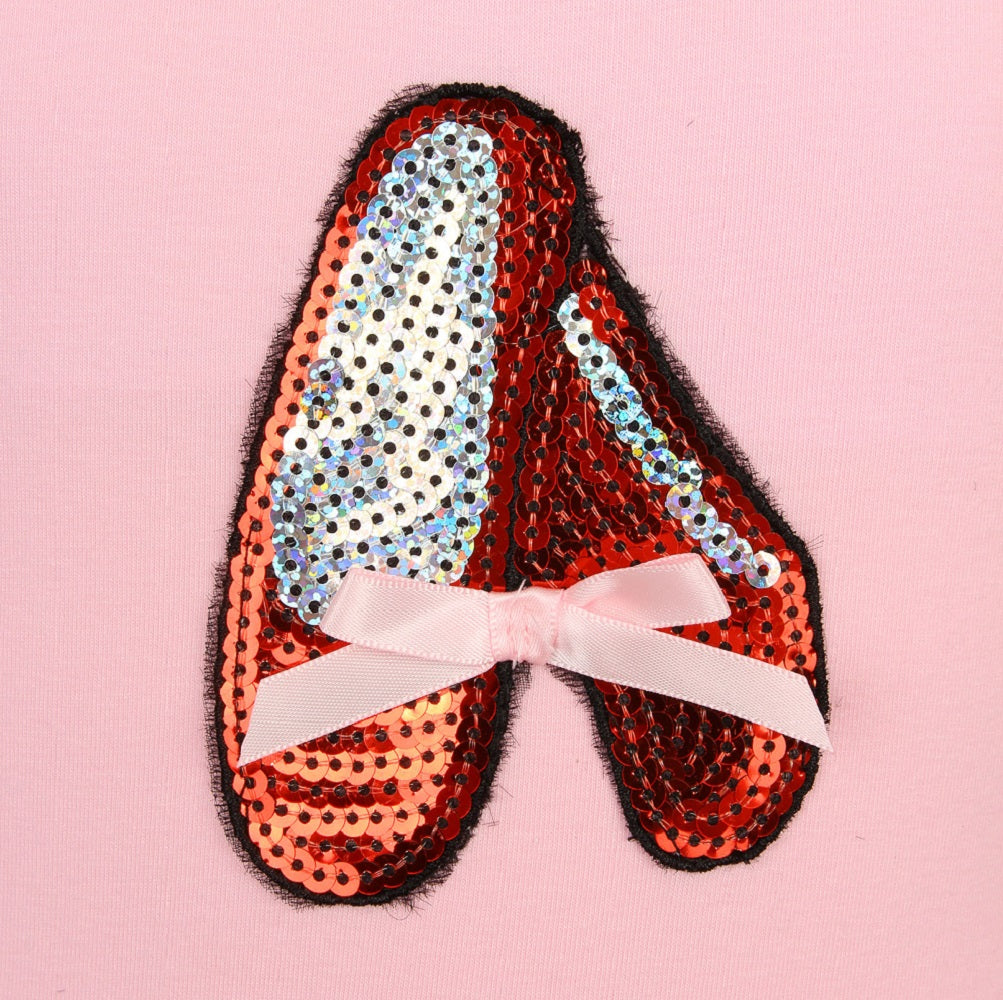 red sequin slippers on a pink leotard