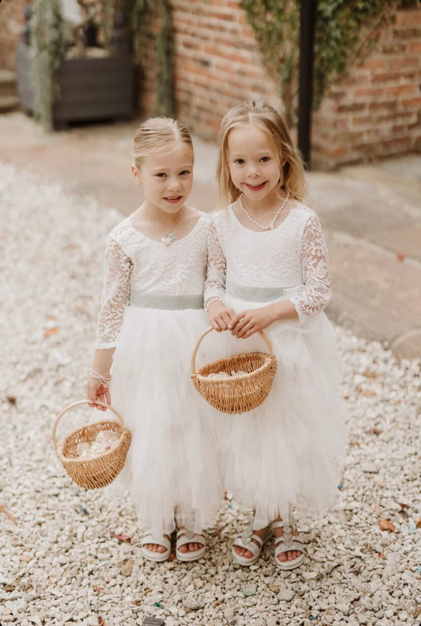Two little flower girls holding baskets
