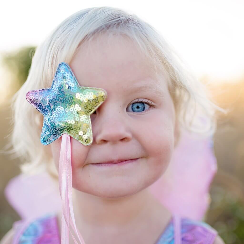 Picture of girls face with star sequinned wand up to her eye